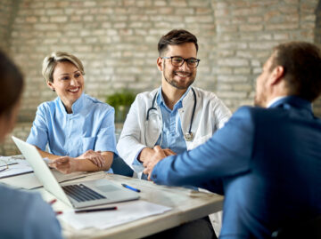 Happy doctor shaking hands with a businessman on a meeting in th